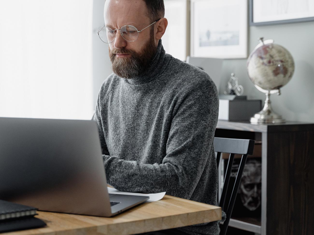 Man wearing glasses and working on laptop